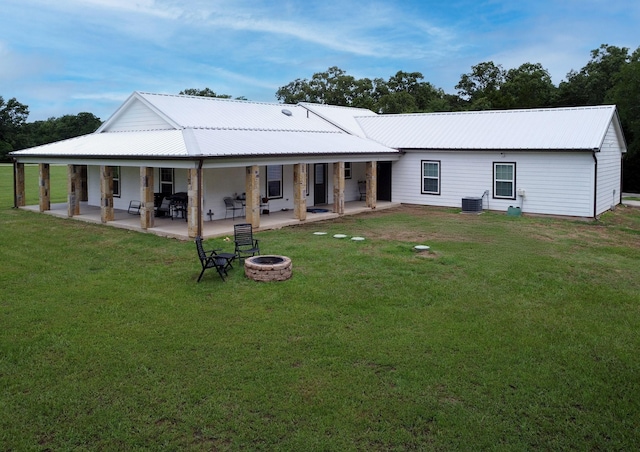 632 County Road 1952, Yantis, TX 75497 - rear view of house featuring an outdoor fire pit, a lawn, metal roof, and a patio