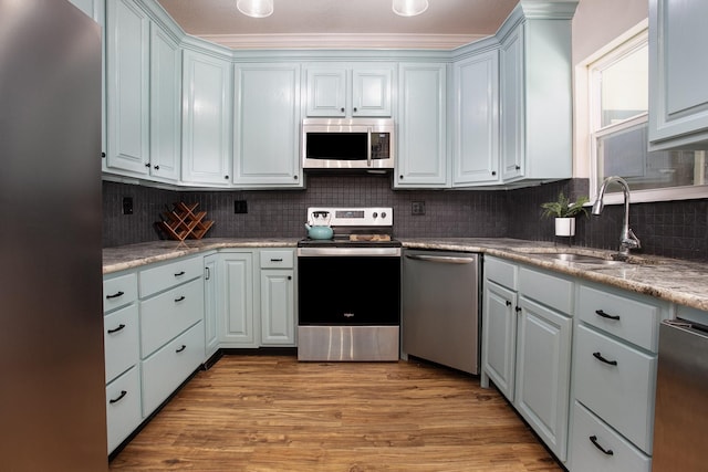 632 County Road 1952, Yantis, TX 75497 - kitchen featuring stainless steel appliances, a sink, backsplash, light wood-type flooring, and light countertops