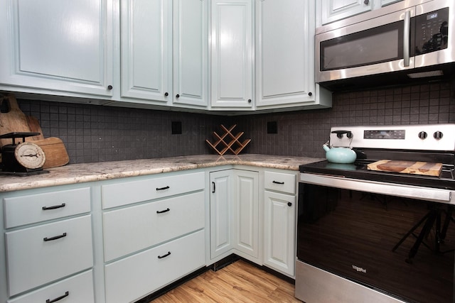 632 County Road 1952, Yantis, TX 75497 - kitchen with appliances with stainless steel finishes, tasteful backsplash, white cabinets, and light countertops