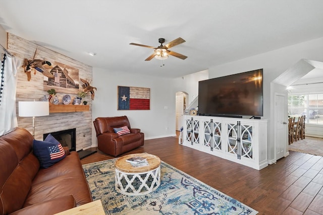 2304 Ranch House Dr, Denton, TX 76210 - living area featuring arched walkways, wood finished floors, ceiling fan, a large fireplace, and baseboards
