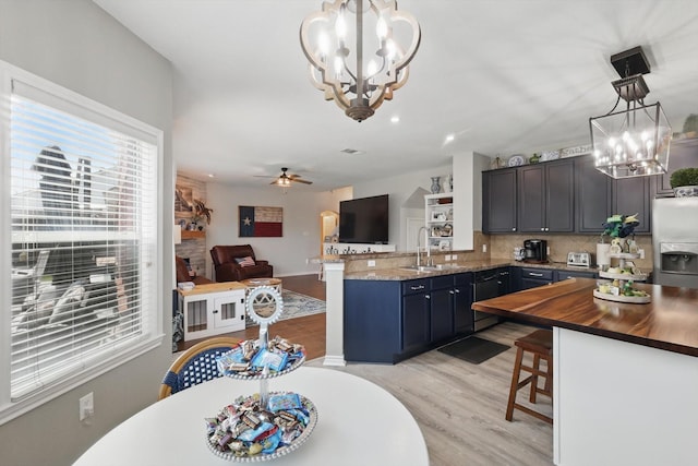 2304 Ranch House Dr, Denton, TX 76210 - kitchen featuring a chandelier, stainless steel fridge with ice dispenser, a sink, a kitchen breakfast bar, and decorative backsplash