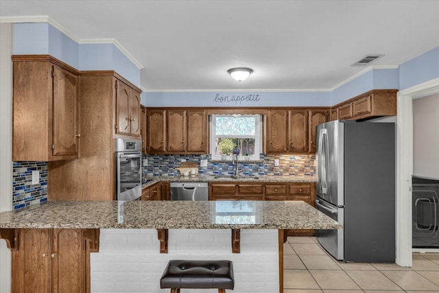 408 Texas Ave, Hewitt, TX 76643 - kitchen with stainless steel appliances, a sink, a peninsula, a breakfast bar, and crown molding