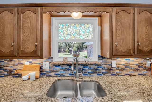 408 Texas Ave, Hewitt, TX 76643 - kitchen with a sink, backsplash, light stone countertops, and brown cabinets