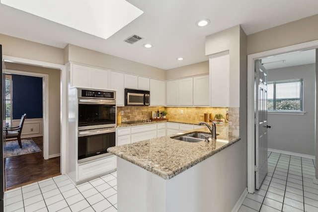 4406 Cobblers Ln, Dallas, TX 75287 - kitchen featuring stainless steel appliances, a sink, white cabinetry, decorative backsplash, and recessed lighting