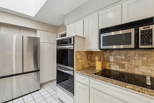 4406 Cobblers Ln, Dallas, TX 75287 - kitchen with stainless steel appliances, white cabinets, backsplash, light stone counters, and light tile patterned floors