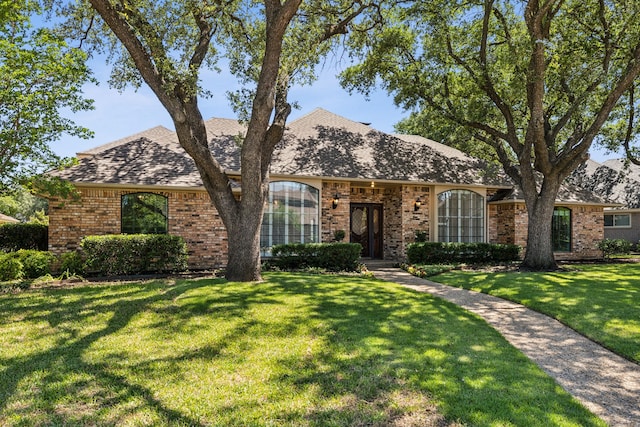 4406 Cobblers Ln, Dallas, TX 75287 - view of front of home featuring brick siding, a front yard, and roof with shingles