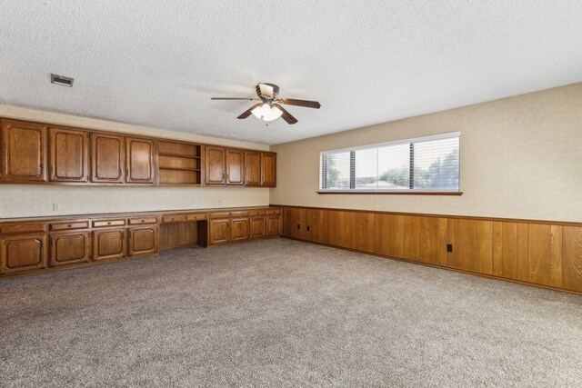 4406 Cobblers Ln, Dallas, TX 75287 - kitchen with brown cabinets, a ceiling fan, open shelves, wainscoting, and carpet flooring