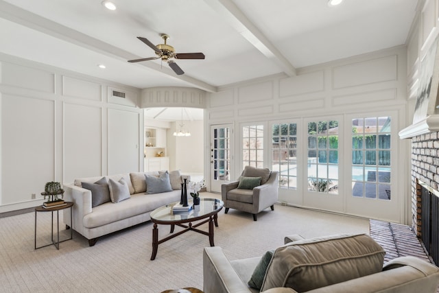 4406 Cobblers Ln, Dallas, TX 75287 - living room with a decorative wall, beamed ceiling, a brick fireplace, a ceiling fan, and a chandelier