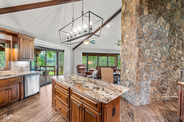 1863 Glen Cove Dr, Benton, LA 71006 - kitchen with stainless steel dishwasher, wood finished floors, light stone counters, brown cabinetry, and a kitchen island