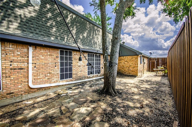 3824 Wagonwheel Ct, Plano, TX 75023 - rear view of property featuring brick siding, roof with shingles, and a patio