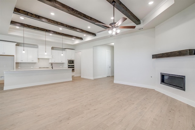 6145 Lucia Dr, Fort Worth, TX 76123 - unfurnished living room featuring beam ceiling, a glass covered fireplace, light wood-type flooring, ceiling fan, and baseboards