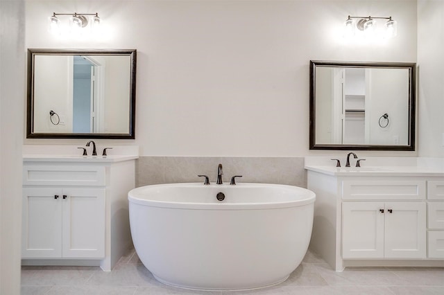 6145 Lucia Dr, Fort Worth, TX 76123 - bathroom featuring a freestanding tub, two vanities, tile patterned flooring, and wainscoting