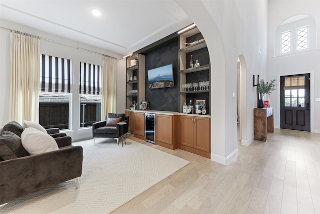 2880 Meadow Dell Dr, Prosper, TX 75078 - indoor dry bar featuring wine cooler, arched walkways, light wood-style flooring, built in shelves, and baseboards