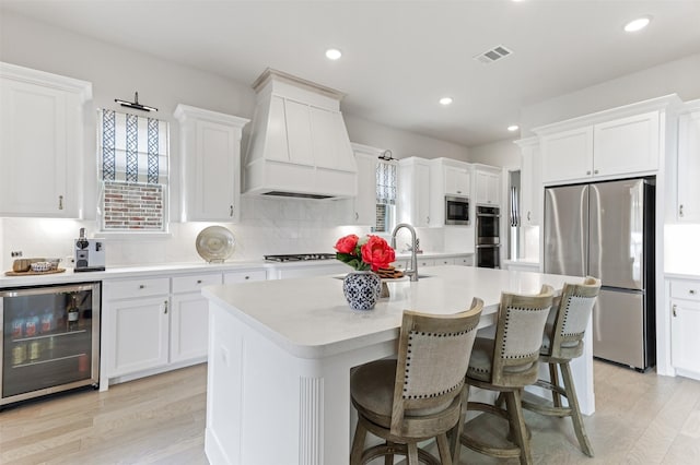 2880 Meadow Dell Dr, Prosper, TX 75078 - kitchen with appliances with stainless steel finishes, beverage cooler, premium range hood, light countertops, and tasteful backsplash