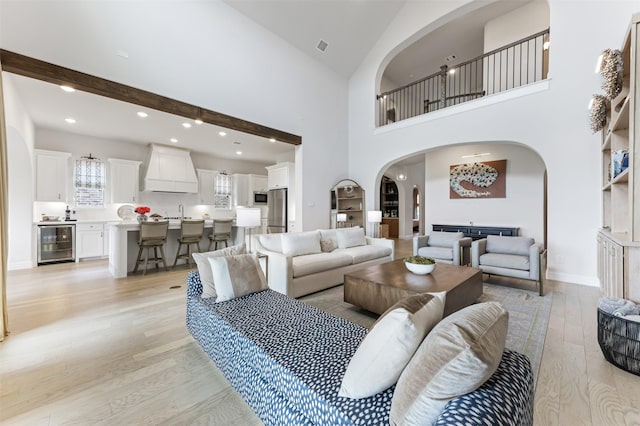 2880 Meadow Dell Dr, Prosper, TX 75078 - living area featuring wine cooler, arched walkways, light wood finished floors, recessed lighting, and baseboards