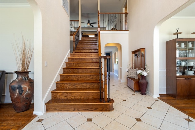1312 Camberley Ct, Keller, TX 76248 - stairs with arched walkways, a ceiling fan, tile patterned flooring, ornamental molding, and baseboards