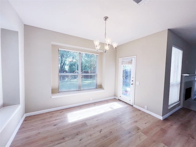 3104 Pataula Ln, Plano, TX 75074 - unfurnished dining area featuring a chandelier, plenty of natural light, wood finished floors, and a fireplace