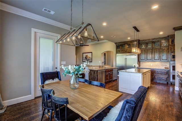 552 Horseshoe Bnd, Royse City, TX 75189 - dining space with arched walkways, dark wood finished floors, crown molding, recessed lighting, and baseboards