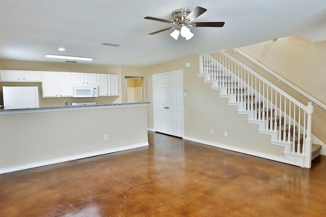 7703 Stanley, Joshua, TX 76058 - kitchen with white microwave, concrete flooring, white cabinets, baseboards, and a ceiling fan