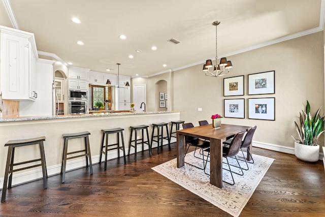 406 Wyndemere Blvd, Heath, TX 75032 - dining area featuring arched walkways, a chandelier, recessed lighting, dark wood-style floors, and ornamental molding