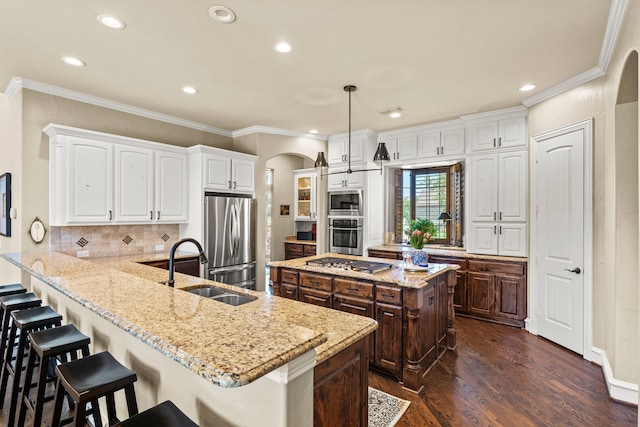 406 Wyndemere Blvd, Heath, TX 75032 - kitchen with appliances with stainless steel finishes, arched walkways, a sink, white cabinetry, and recessed lighting