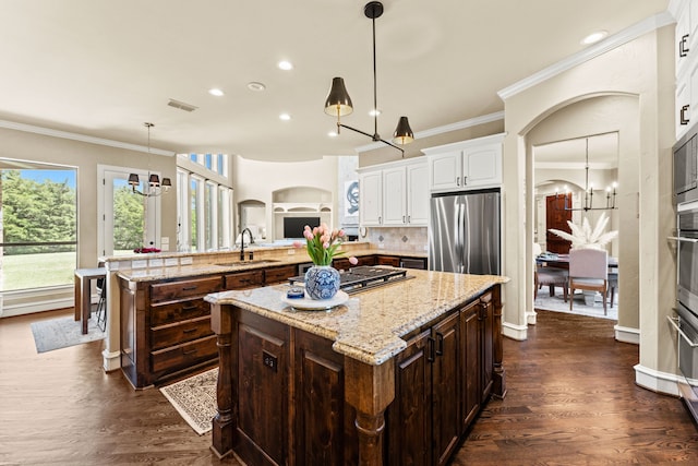 406 Wyndemere Blvd, Heath, TX 75032 - kitchen with appliances with stainless steel finishes, a sink, arched walkways, white cabinetry, and a chandelier
