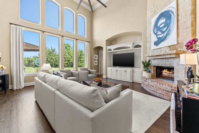 406 Wyndemere Blvd, Heath, TX 75032 - living area with ornamental molding, a large fireplace, dark wood finished floors, a towering ceiling, and baseboards