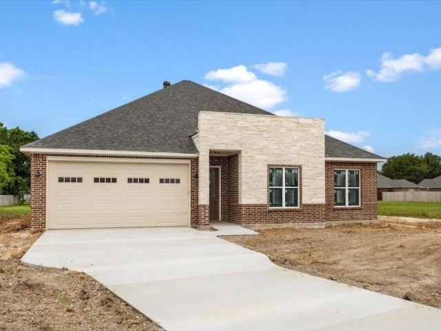 2799 Fm-3218, Commerce, TX 75428 - view of front facade with driveway, a garage, roof with shingles, brick siding, and stone siding