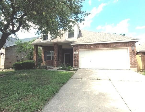 1207 Goldeneye, Aubrey, TX 76227 - view of front of home featuring a garage, concrete driveway, brick siding, and a front yard