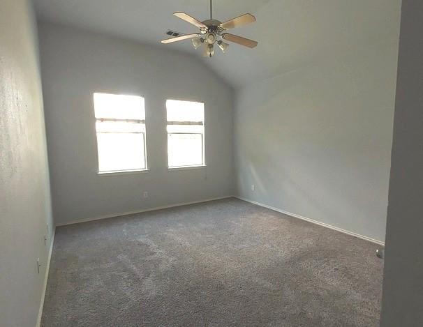 1207 Goldeneye, Aubrey, TX 76227 - spare room with ceiling fan, carpet floors, vaulted ceiling, and baseboards