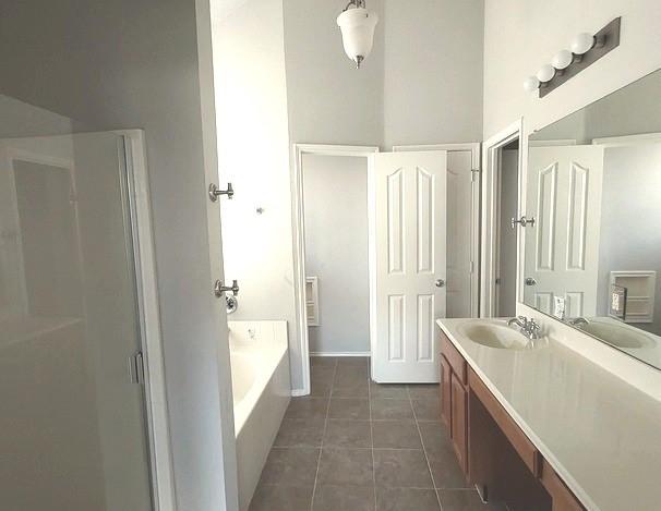 1207 Goldeneye, Aubrey, TX 76227 - full bathroom with tile patterned flooring, vanity, a garden tub, and a shower stall