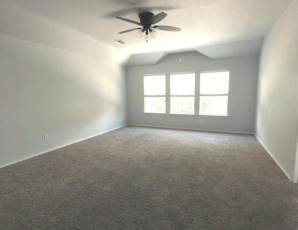 1207 Goldeneye, Aubrey, TX 76227 - carpeted empty room featuring ceiling fan, lofted ceiling, and baseboards