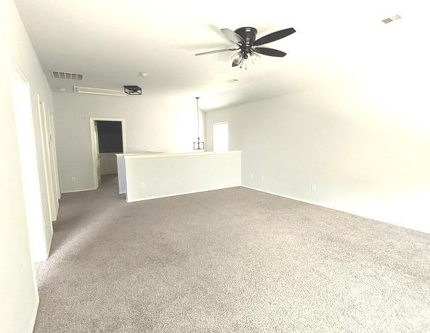 1207 Goldeneye, Aubrey, TX 76227 - unfurnished living room featuring carpet floors, ceiling fan, and attic access