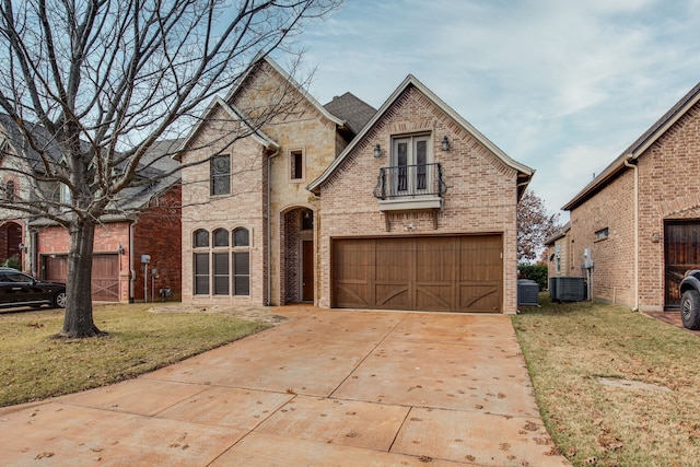 3317 S Riley Ct, Hurst, TX 76054 - view of front of home featuring a balcony, a front yard, brick siding, driveway, and central air condition unit