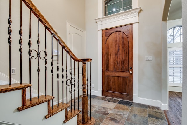 3317 S Riley Ct, Hurst, TX 76054 - entrance foyer with baseboards, arched walkways, stairway, and stone finish flooring