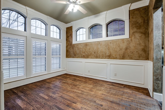 3317 S Riley Ct, Hurst, TX 76054 - spare room with a ceiling fan, a decorative wall, dark wood-style flooring, and wainscoting
