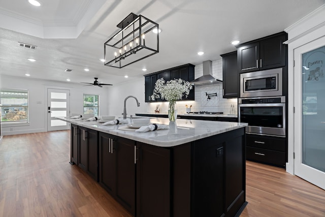 5316 Humbert Ave, Fort Worth, TX 76107 - kitchen featuring stainless steel appliances, wall chimney exhaust hood, dark cabinets, tasteful backsplash, and recessed lighting