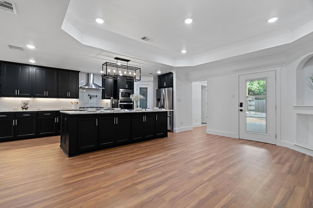 5316 Humbert Ave, Fort Worth, TX 76107 - kitchen featuring dark cabinetry, wall chimney exhaust hood, a raised ceiling, light countertops, and decorative backsplash