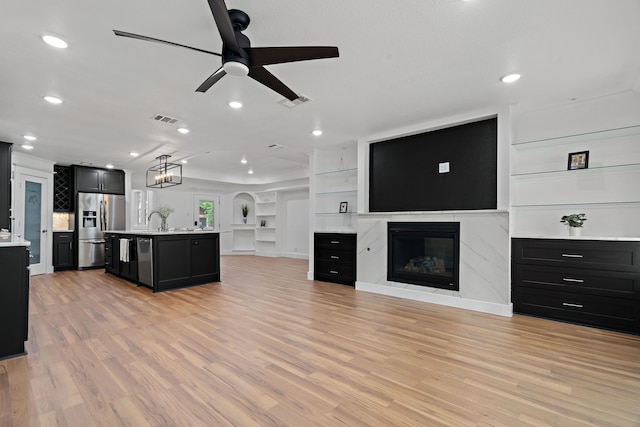 5316 Humbert Ave, Fort Worth, TX 76107 - unfurnished living room featuring ceiling fan, a glass covered fireplace, light wood-type flooring, recessed lighting, and a sink