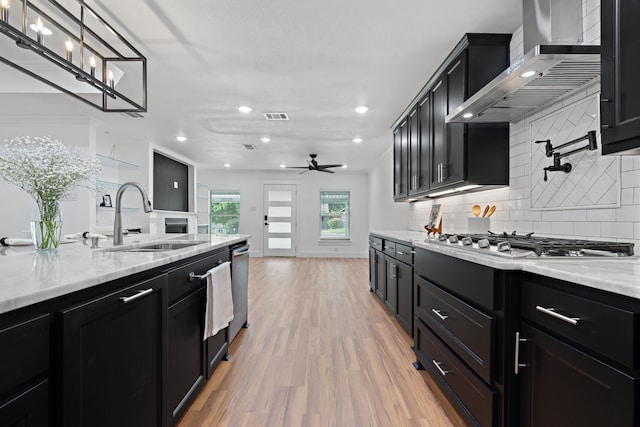 5316 Humbert Ave, Fort Worth, TX 76107 - kitchen with a sink, wall chimney range hood, dark cabinetry, appliances with stainless steel finishes, and recessed lighting