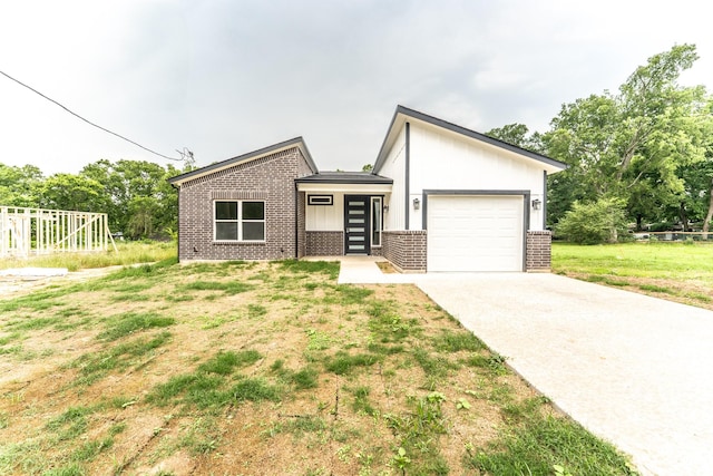 128 Goodman St, Sulphur Springs, TX 75482 - view of front of property with brick siding, concrete driveway, an attached garage, and a front yard