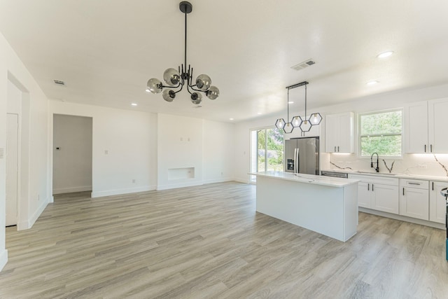 128 Goodman St, Sulphur Springs, TX 75482 - kitchen featuring stainless steel refrigerator with ice dispenser, a sink, a kitchen island, light wood-style flooring, and recessed lighting