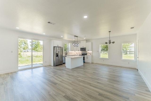 128 Goodman St, Sulphur Springs, TX 75482 - unfurnished living room with healthy amount of natural light, a chandelier, recessed lighting, and baseboards