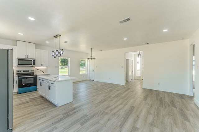 128 Goodman St, Sulphur Springs, TX 75482 - kitchen featuring stainless steel appliances, open floor plan, white cabinetry, a chandelier, and recessed lighting
