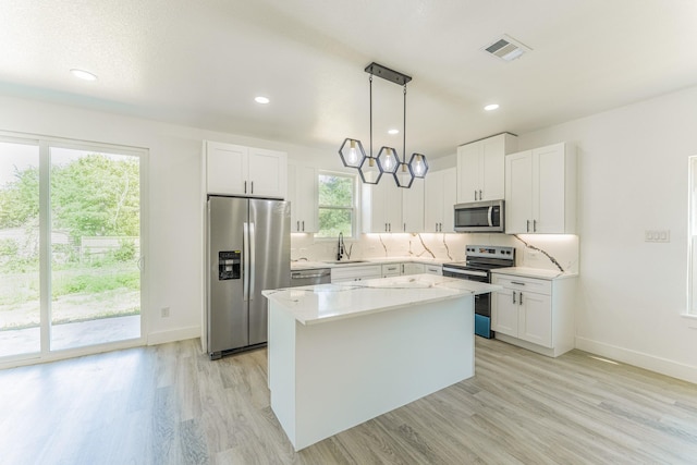 128 Goodman St, Sulphur Springs, TX 75482 - kitchen with appliances with stainless steel finishes, light wood finished floors, decorative backsplash, white cabinetry, and a sink