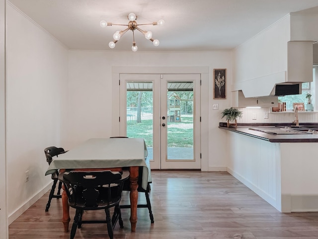 461 E Bradley St, Fairfield, TX 75840 - dining area with a chandelier, french doors, ornamental molding, light wood-style flooring, and baseboards
