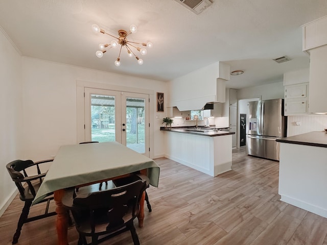 461 E Bradley St, Fairfield, TX 75840 - dining room featuring french doors, a chandelier, light wood-style floors, and baseboards