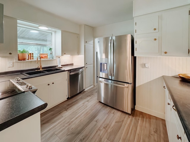 461 E Bradley St, Fairfield, TX 75840 - kitchen featuring stainless steel appliances, a sink, dark countertops, white cabinets, and light wood-type flooring