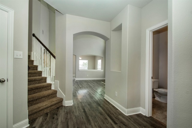 3613 Pisa Mews, Dallas, TX 75236 - hall featuring arched walkways, dark wood-type flooring, baseboards, and stairs