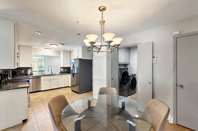 7109 Alpha Rd, Dallas, TX 75240 - dining space featuring washer and clothes dryer, a chandelier, and light tile patterned floors